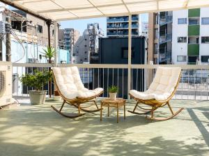 two chairs and a table on a balcony at Lee Ryokan Tokyo in Tokyo