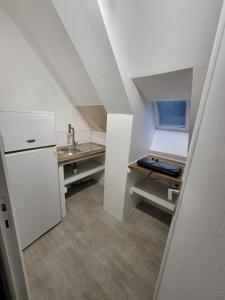 a small kitchen with a sink and a refrigerator at Bolumet in Neulliac