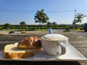 ein Teller mit einer Tasse Kaffee und Brot auf einem Tisch in der Unterkunft The Schoolhouse Hotel in Swindon