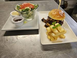 ein Sandwich und Pommes frites auf einem Teller mit Salat in der Unterkunft The Schoolhouse Hotel in Swindon + 13 Fotos