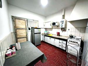 a kitchen with white appliances and a red floor at La Casa de Pilar - Casa Completa con Cochera y Patio in San Juan