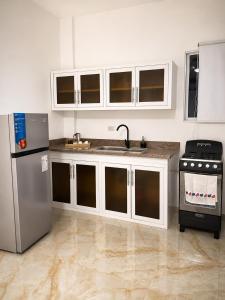 a kitchen with a sink and a refrigerator at Alojamiento en Miches in Miches