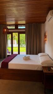 a bedroom with a large bed and a window at Bossa Atins in Atins
