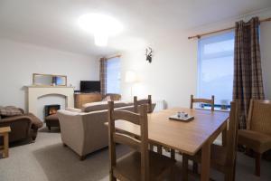 a living room with a table and a fireplace at Blair Drummond Holiday Home in Doune