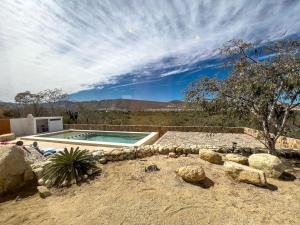 a swimming pool in the middle of a desert with rocks at Los Domecitos - Geodesic Dome Retreat in Los Barriles