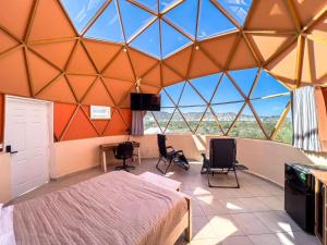 a room with a bed and chairs in a tent at Los Domecitos - Geodesic Dome Retreat in Los Barriles