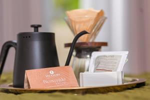 a plate with a coffee pot and a card on it at Veca Flats Centenario in Cali