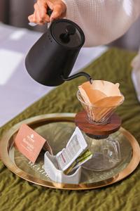 a person is holding a kettle on a table at Veca Flats Centenario in Cali