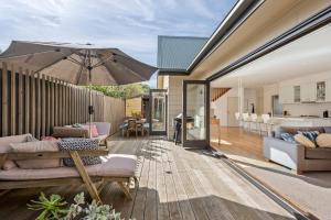a patio with an umbrella and a living room at Kassandra in Point Lonsdale
