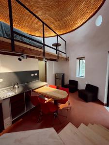 a room with a table and a loft bed at La cabaña del jaguar in Tepoztlán