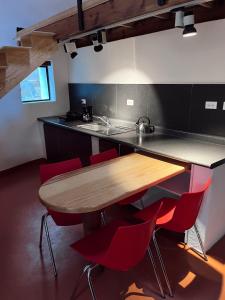 a kitchen with a wooden table and red chairs at La cabaña del jaguar in Tepoztlán +12 photos