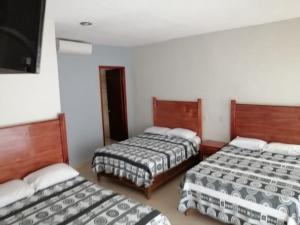 a room with three beds in a room at La Gloria Hotel Xilitla in Xilitla