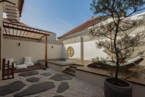 a courtyard with a tree and a swimming pool at YŪN Uluwatu in Uluwatu
