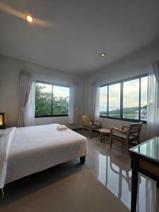 a bedroom with a bed and a desk and windows at Anda Sea view in Klong Muang Beach +19 photos