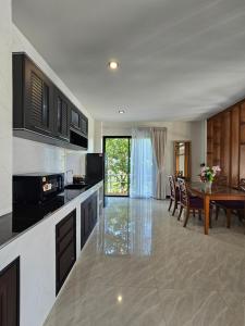 a kitchen with a table and a dining room at Anda Sea view in Klong Muang Beach