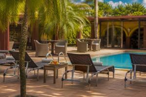 a group of chairs and tables next to a pool at La Locanda Art & Taste Retreat in Puerto Iguazú