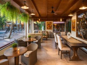 a restaurant with tables and chairs and a patio at La Locanda Art & Taste Retreat in Puerto Iguazú