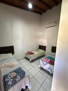 a room with two beds in a room at Hotel E Pousada do Patrão in Bataguaçu