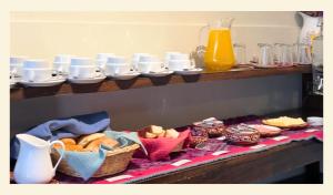 a table with baskets of food and cups on a shelf at Wakapunku Boutique B&B in Cusco