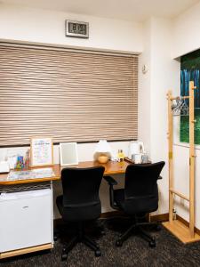 an office with a desk with two chairs and a window at Lee Ryokan Tokyo in Tokyo