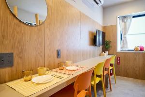 a dining room with a long table and yellow chairs at DreamFriend新浦安 in Tokyo