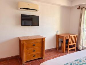 ein Schlafzimmer mit Schreibtisch und Fernseher an der Wand in der Unterkunft Amet Hotel Boutique in La Paz