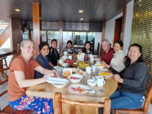 a group of people sitting around a table eating food at Hosteria Chyrywasy Home in Ibarra