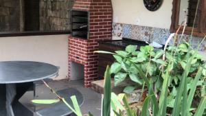 a patio with a table and a brick oven at Vista dos Vales - Vila Real do Vau, próximo a São Gonçalo, Milho Verde, Diamantina in Diamantina