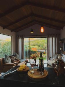 a living room with a table with two glasses of wine at Vista dos Vales - Vila Real do Vau, próximo a São Gonçalo, Milho Verde, Diamantina in Diamantina