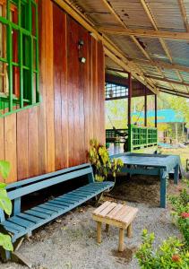 a patio with two benches and a table at Playa Verde Lodge in Bahía Solano
