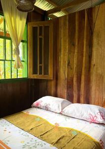 a bed in a room with a window at Playa Verde Lodge in Bahía Solano +8 photos