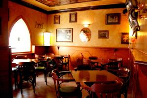 a restaurant with tables and chairs and a window at Hosteria Gante in Jarandilla de la Vera