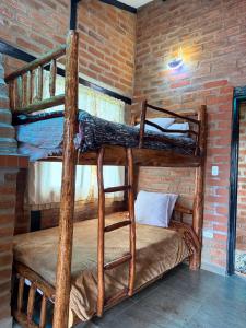 a room with two bunk beds in a brick wall at Hosteria Chyrywasy Home in Ibarra