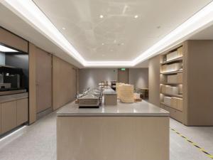 a room with a kitchen with a counter with appliances at JI Hotel Beijing Panjiayuan in Beijing
