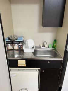 a small kitchen with a sink and a counter at アルゴ境川 in Kitakyushu