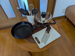 a table with a frying pan and utensils on it at La Curación in Naoshima