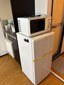 a microwave sitting on top of a refrigerator at アルゴ境川 in Kitakyushu