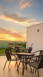 a group of chairs and a table on a balcony at Pousada Acessus Executivo - Cozinha e Lavanderia in Anápolis