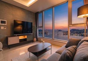 a living room with a couch and a large window at Le Collective Busan station in Busan
