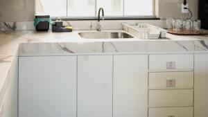 a kitchen with white cabinets and a sink at Pousada Acessus Executivo - Cozinha e Lavanderia in Anápolis +76 photos