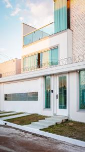 a white building with stairs in front of it at Pousada Acessus Executivo - Cozinha e Lavanderia in Anápolis