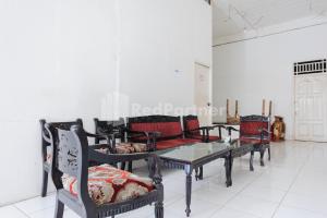 a group of chairs and a table in a room at Ombai Guest House 27 Syariah Mitra RedDoorz in Kertapati