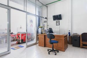an office with a desk and a chair in a room at Ombai Guest House 27 Syariah Mitra RedDoorz in Kertapati