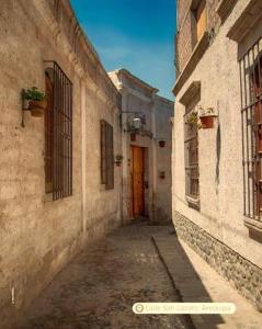 an alley with a red door in an old building at Hospedaje Totocha Yanahuara Arequipa in Yanahuara