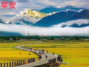 a group of people walking around a field with mountains at Mi Xiang Homestay in Chishang