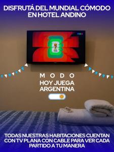 a television on a wall in a room with a bed at Hotel Andino in La Rioja