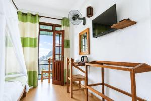 a bedroom with a bed and a tv and a desk at Onestar Ella in Ella