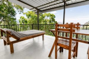 a porch with a bed and a chair on a balcony at Onestar Ella in Ella