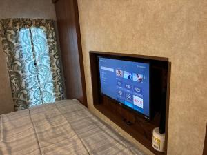 a flat screen tv in a room with a window at My Little RV Getaway in Pass Christian