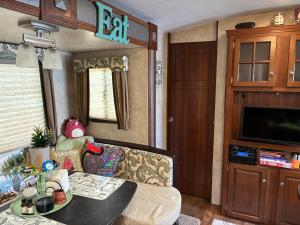 an rv living room with a couch and a table at My Little RV Getaway in Pass Christian
